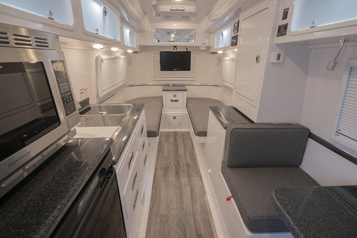 Travel trailer interior with dark FiberGranite countertops down one side