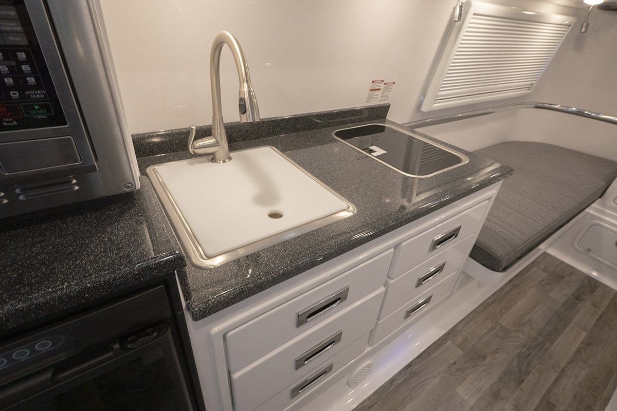 Dark FiberGranite countertop with a white sink in a travel trailer galley