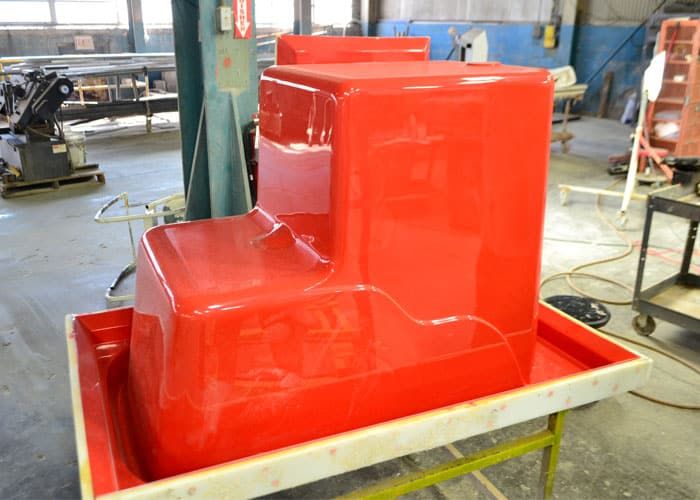 Glossy red production mold sitting in its flange on the shop floor