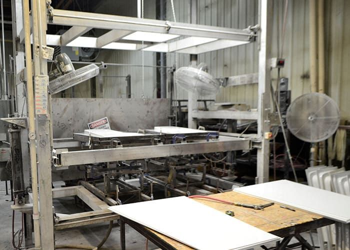 Thermoforming station with white plastic sheet staged on the table in front