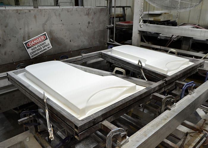 Formed white panels clamped in their frames after thermoforming