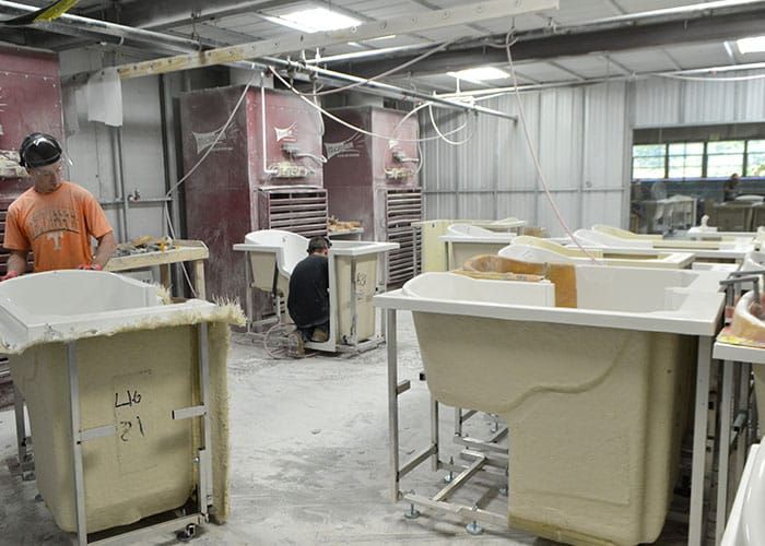 Molded tub shells on stands in the finishing area