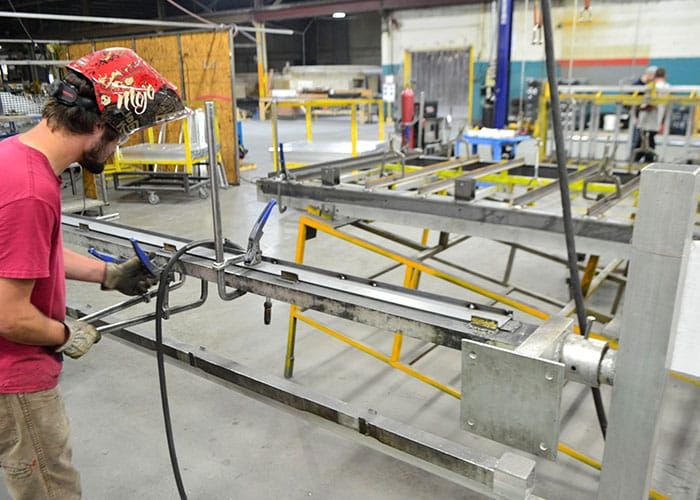 Welder working on a long aluminum frame
