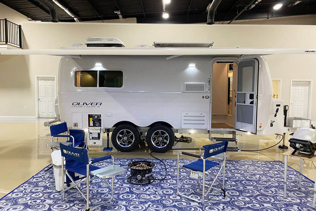 Oliver Legacy Elite II fiberglass travel trailer set up with camp chairs
