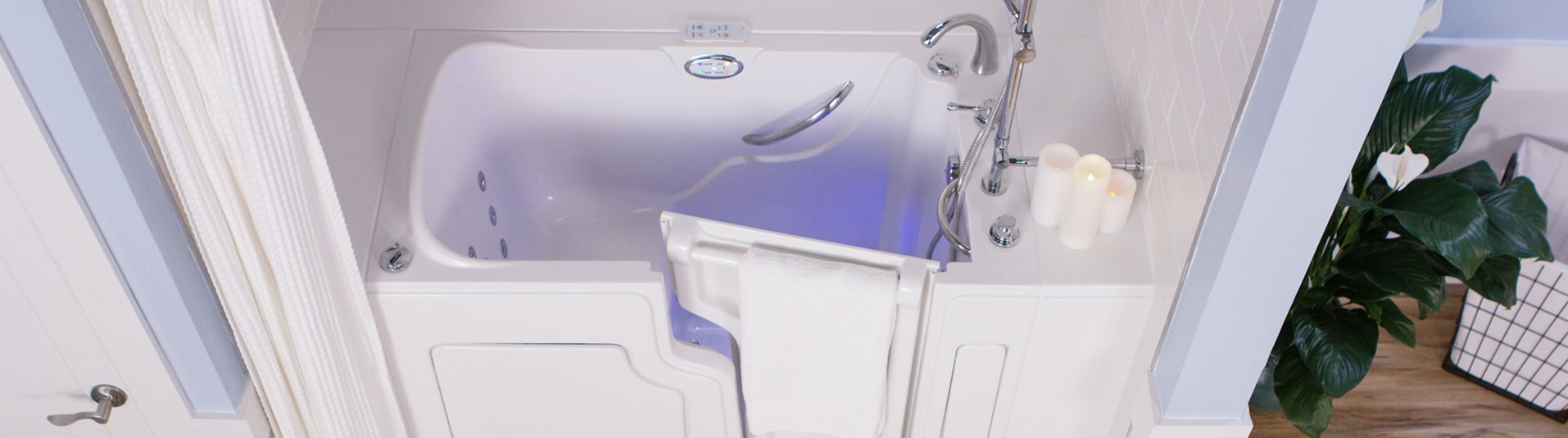 Walk-in tub with its door open and interior lighting on, in a white bathroom